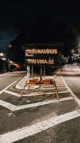 Placa eletrônica: Coronavírus, Previna-se instalada numa bifurcação com duas ruas vazias